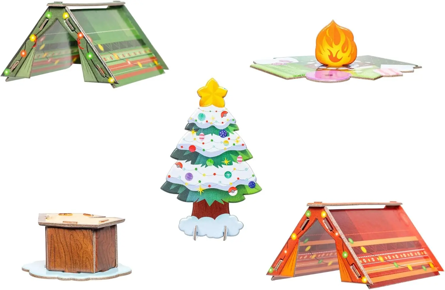 Los cinco accesorios de cartón del calendario de adviento Pokémon 2026: dos tiendas de campaña, árbol de Navidad, tocón y hoguera