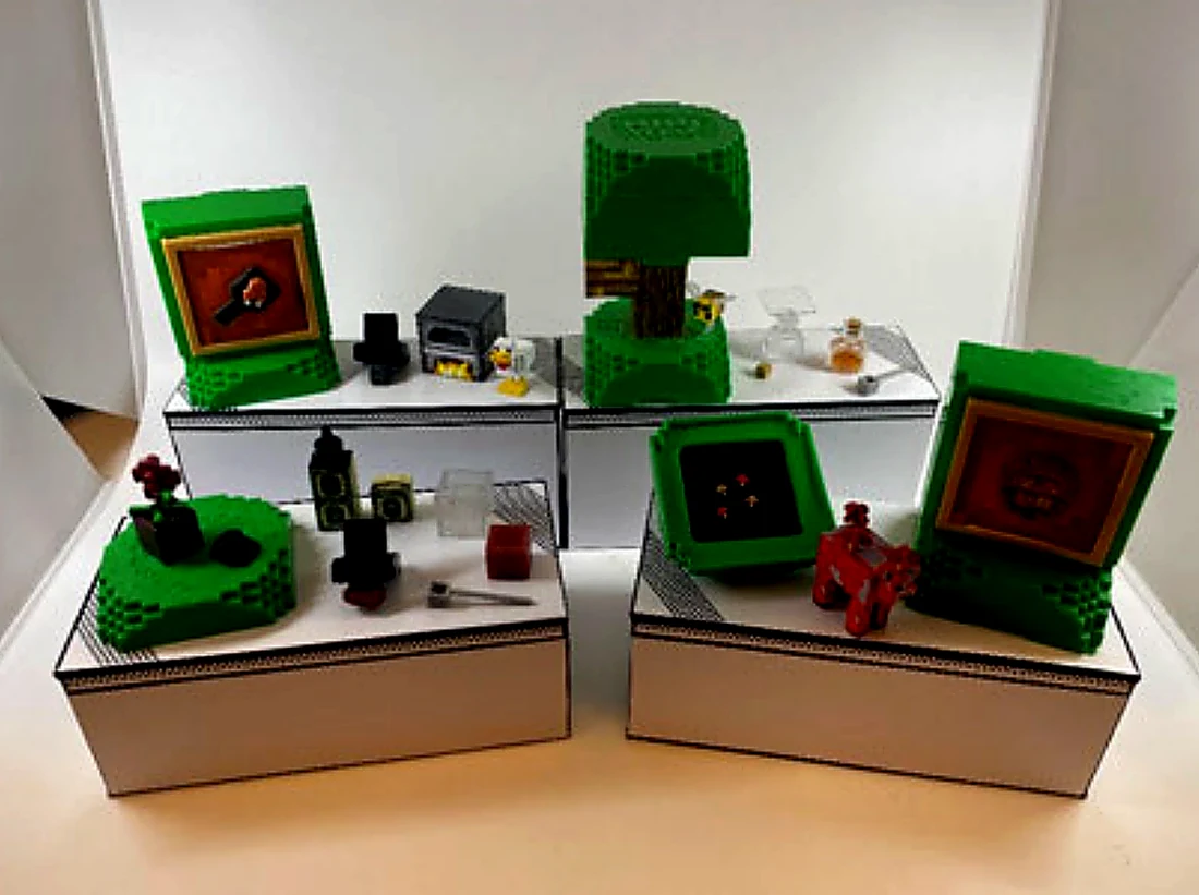 Diorama del cat&aacute;logo MGA 2026 con las c&aacute;psulas cuadradas de la Serie 2: cocina con un patito, &aacute;rbol con abeja, flores rojas y una figura roja tipo Champi&ntilde;aca