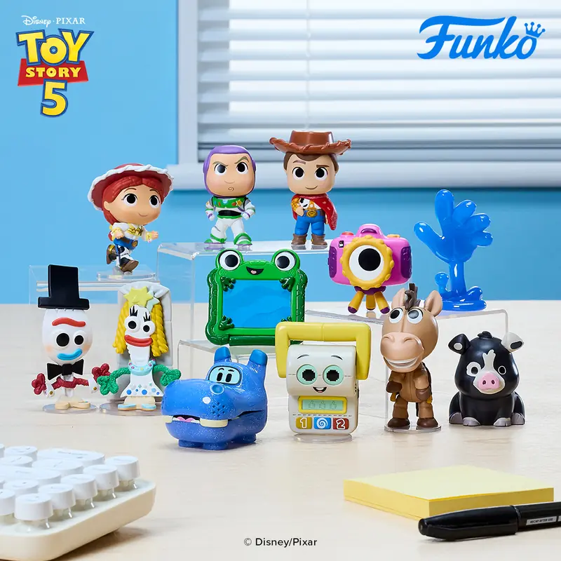 Las 12 figuras Mystery Minis de Toy Story 5 colocadas sobre una mesa: Woody, Buzz, Jessie, Bullseye, Atlas, Snappy, Smarty Pants, Lilypad, Forky y Karen Beverly
