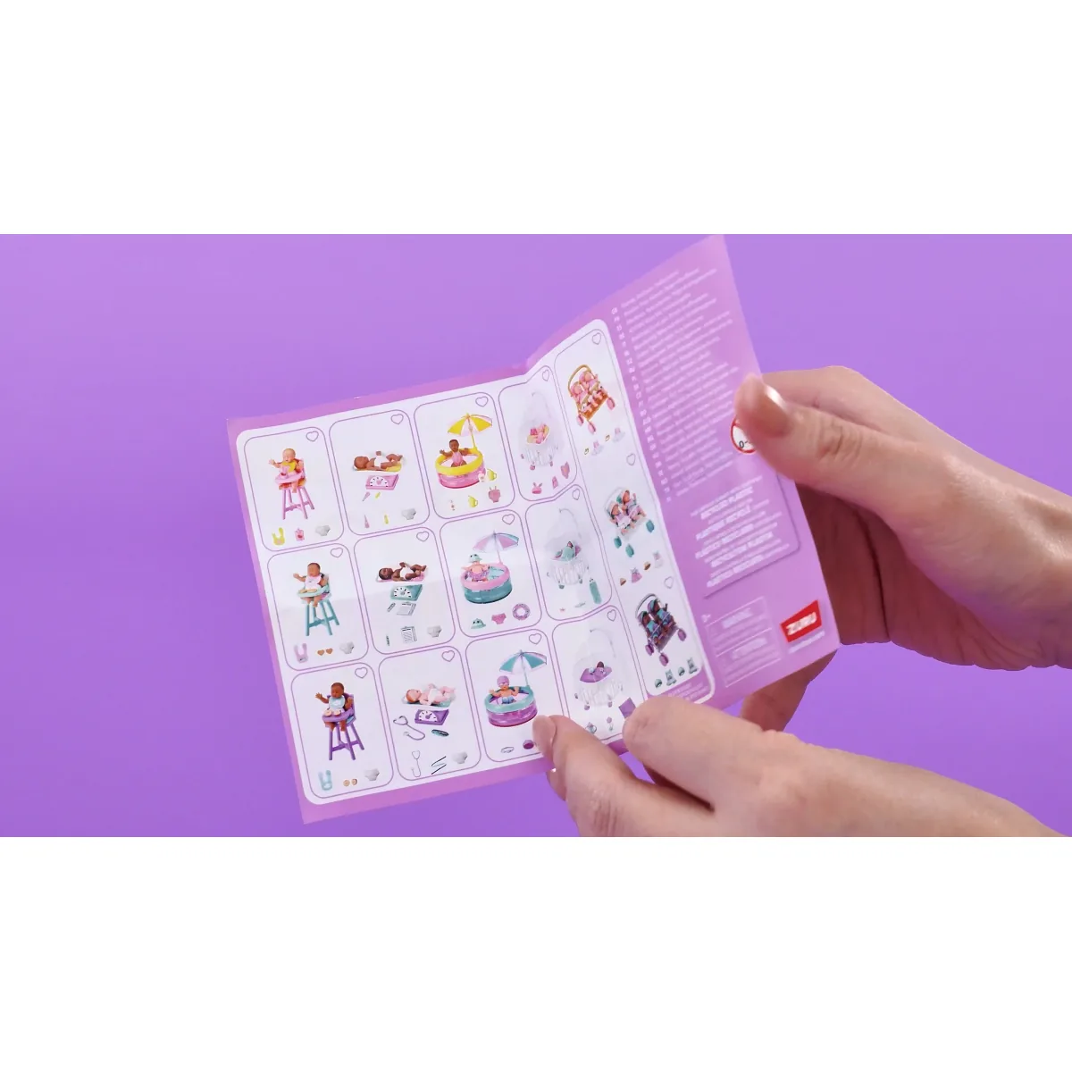 Folleto de papel de My Mini Baby Serie 2 abierto entre dos manos, con las 15 casillas de la colección