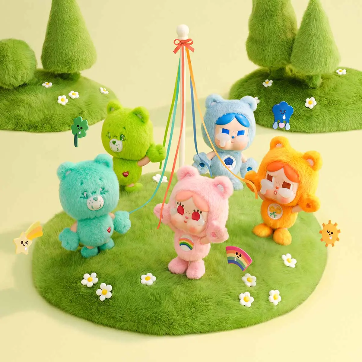 Colgantes CRYBABY x Care Bears de POP MART sobre una pradera, con la cara de vinilo de CRYBABY y el cuerpo de peluche de colores