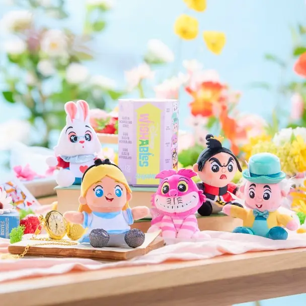 Peluches Wishables Shimmer de Alice in Wonderland 75 aniversario en una escena ambientada con flores y reloj de bolsillo