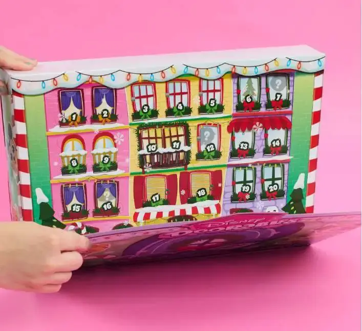 Interior del calendario de Adviento Disney Doorables 2026 con ventanas numeradas en fachadas navideñas