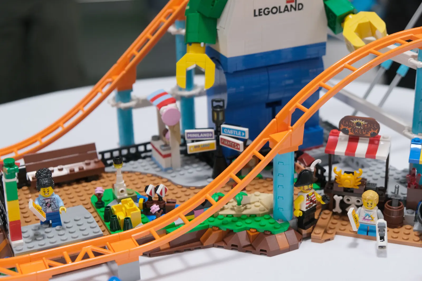 Detalle del LEGO 50090 con el poste indicador hacia Miniland, Castle y Pirates, el mini Miniland y la vía naranja de la montaña rusa