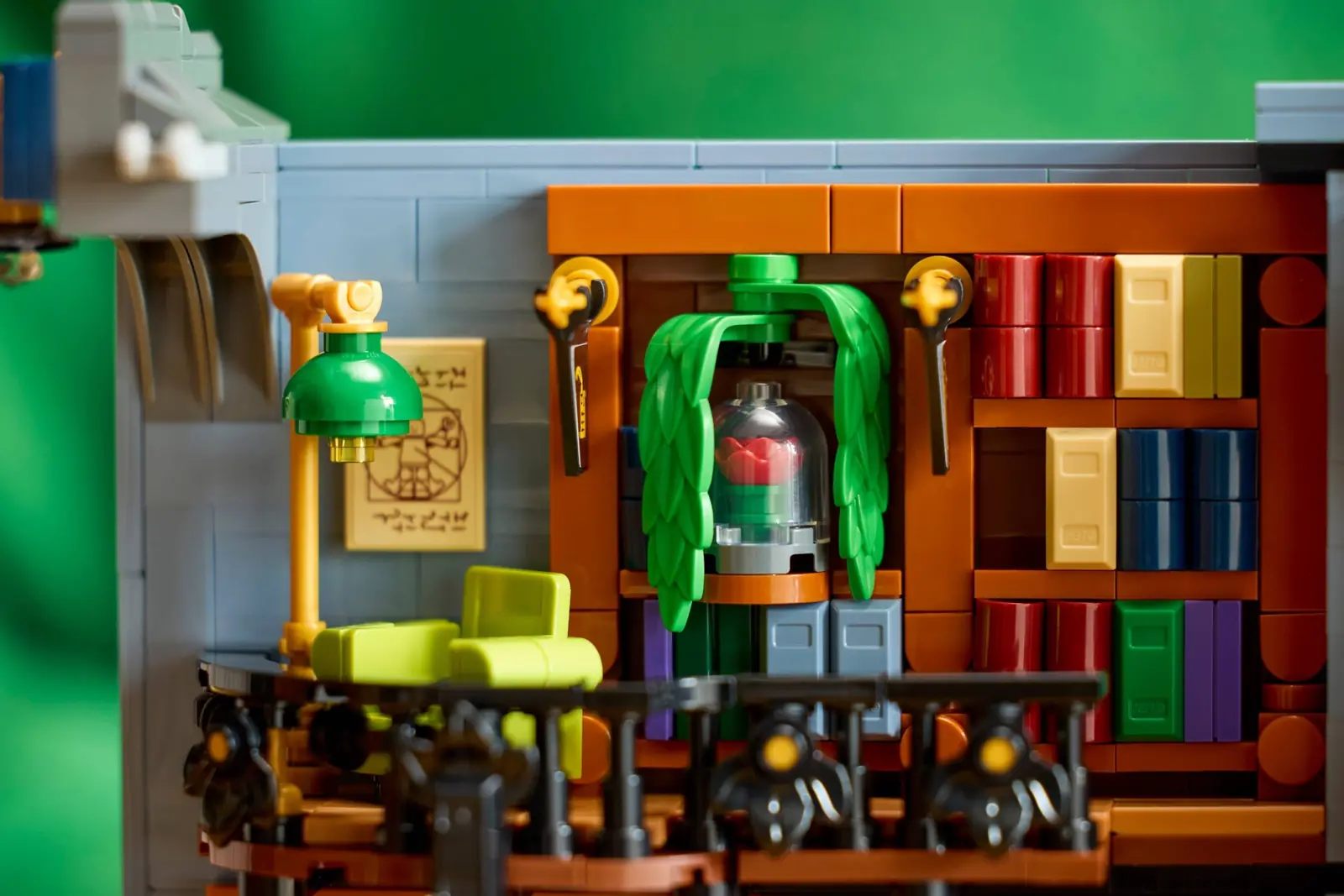 Detalle del LEGO 11379 con una rosa roja bajo campana transparente entre hojas y una lámina que recuerda al Hombre de Vitruvio