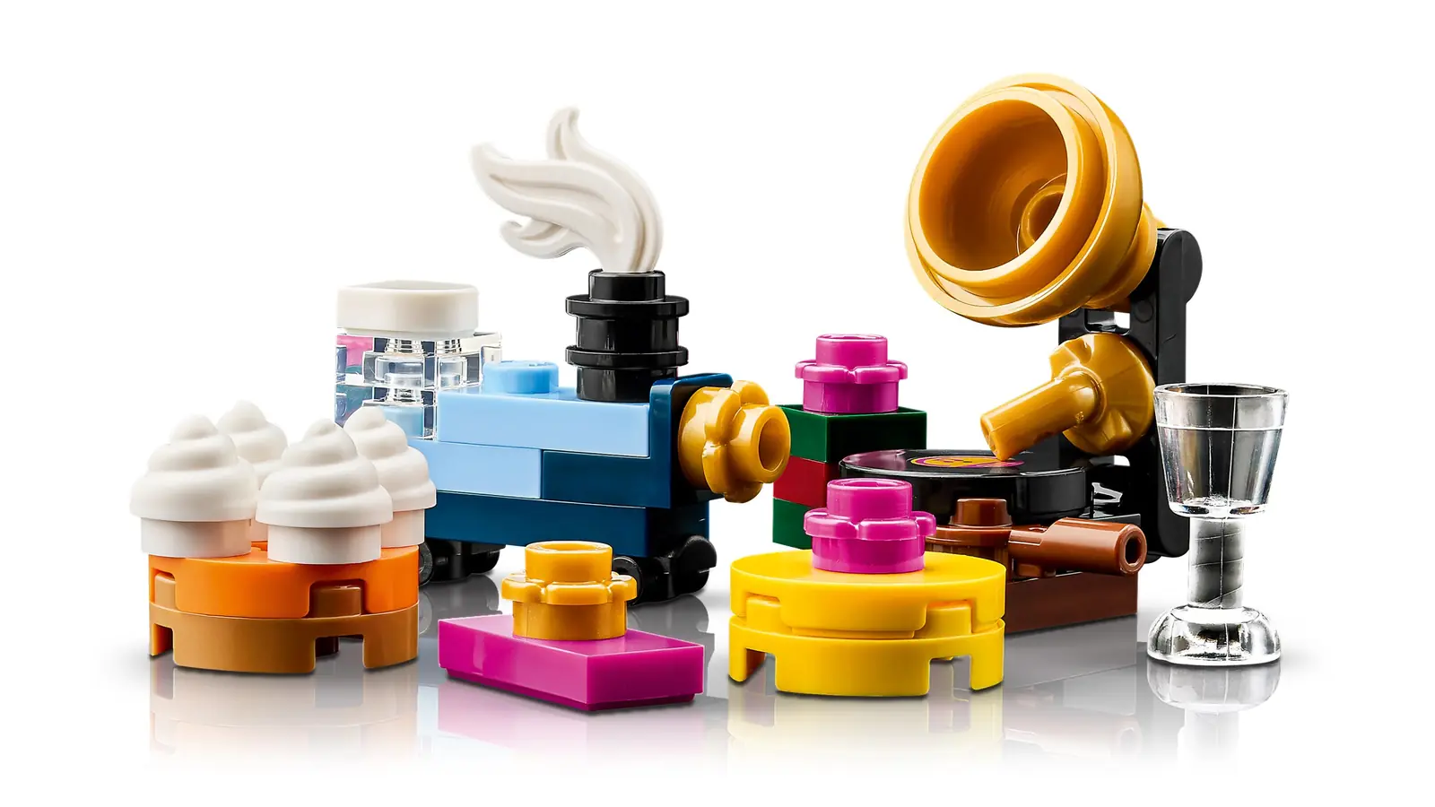 Accesorios del LEGO 11387: trenecito de juguete azul, gramófono dorado, magdalenas, copa y regalos
