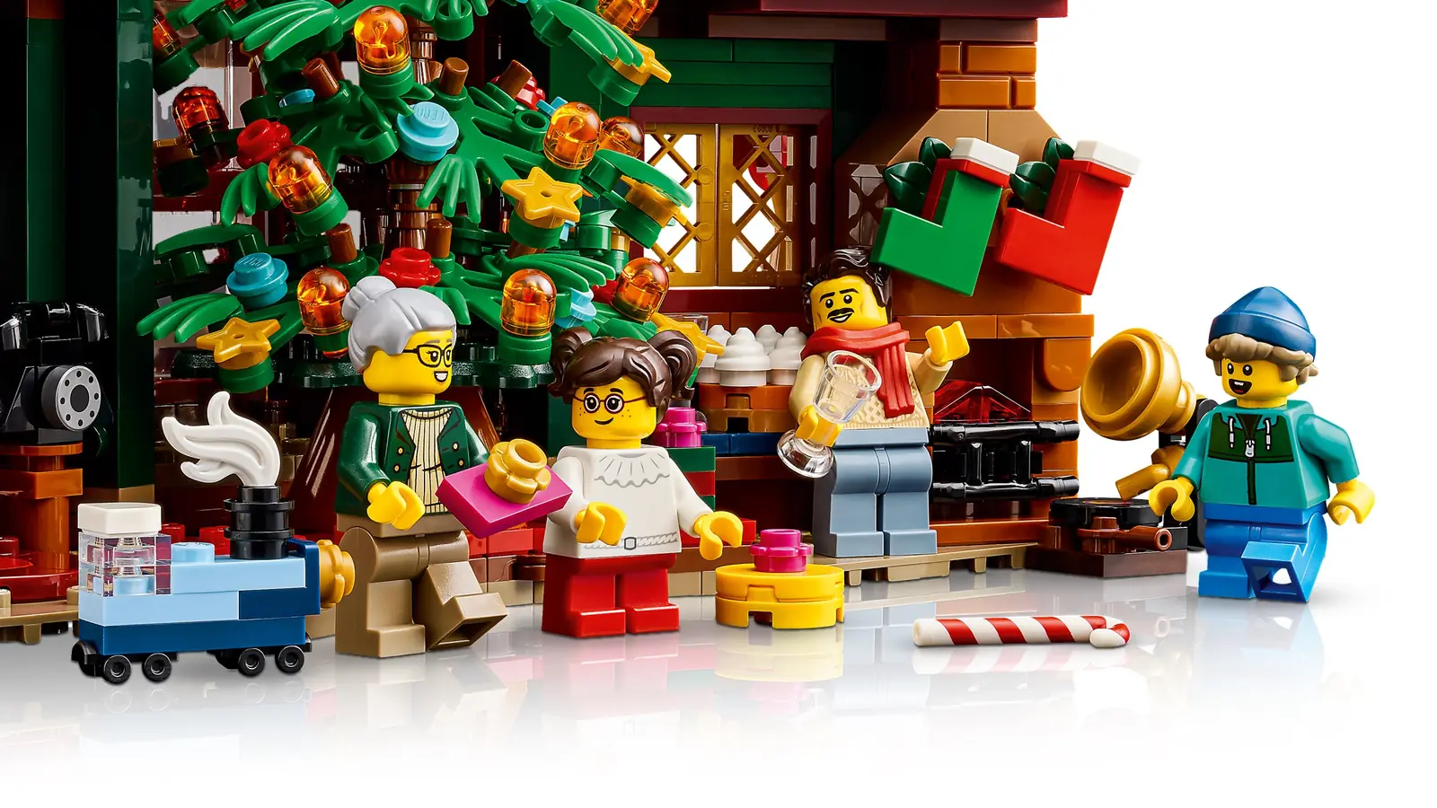 Interior del LEGO 11387 con la chimenea, calcetines, gramófono dorado, teléfono negro y minifiguras junto al árbol