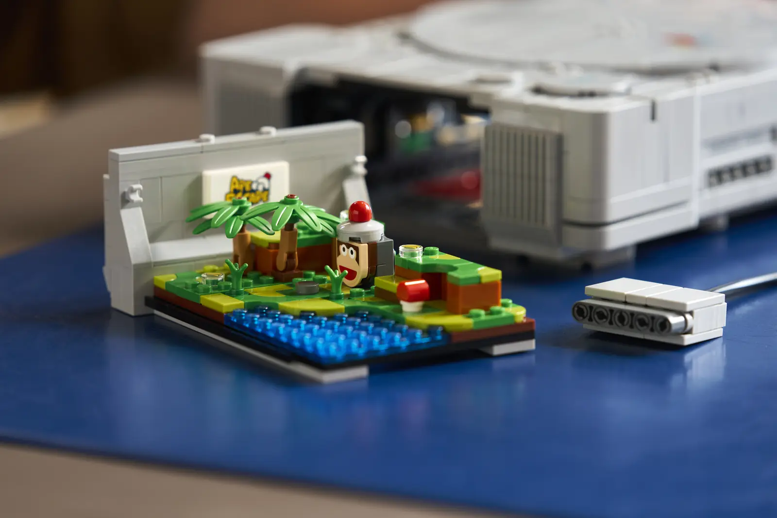 Diorama de Ape Escape del set LEGO PlayStation 72306: isla tropical con palmeras, agua en piezas transparentes y un mono con casco rojo