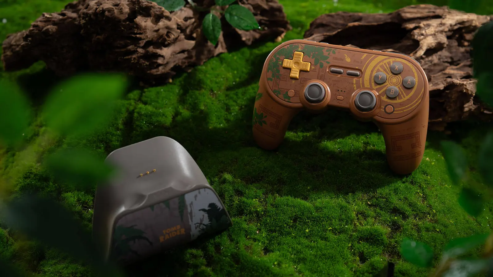 Mando 8BitDo Pro 3 Tomb Raider 30th Anniversary con su base de carga sobre musgo, inspirado en el Lost Valley