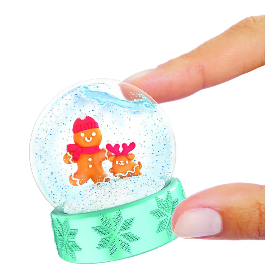La bola de nieve de Miniverse Holiday Series 4 sostenida entre los dedos, como referencia de escala