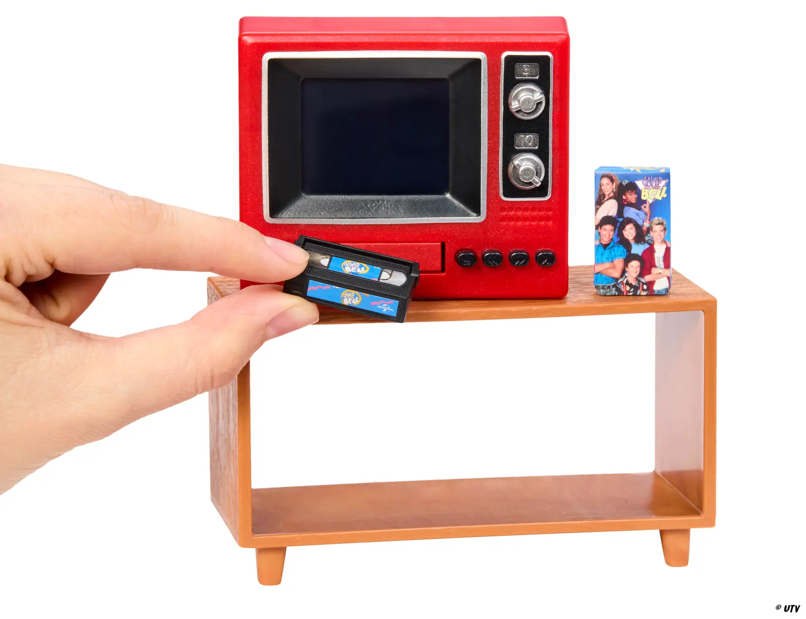 Una mano introduce la cinta de Salvados por la campana en la ranura del Miniverse Real TV, que apoya sobre su mueble