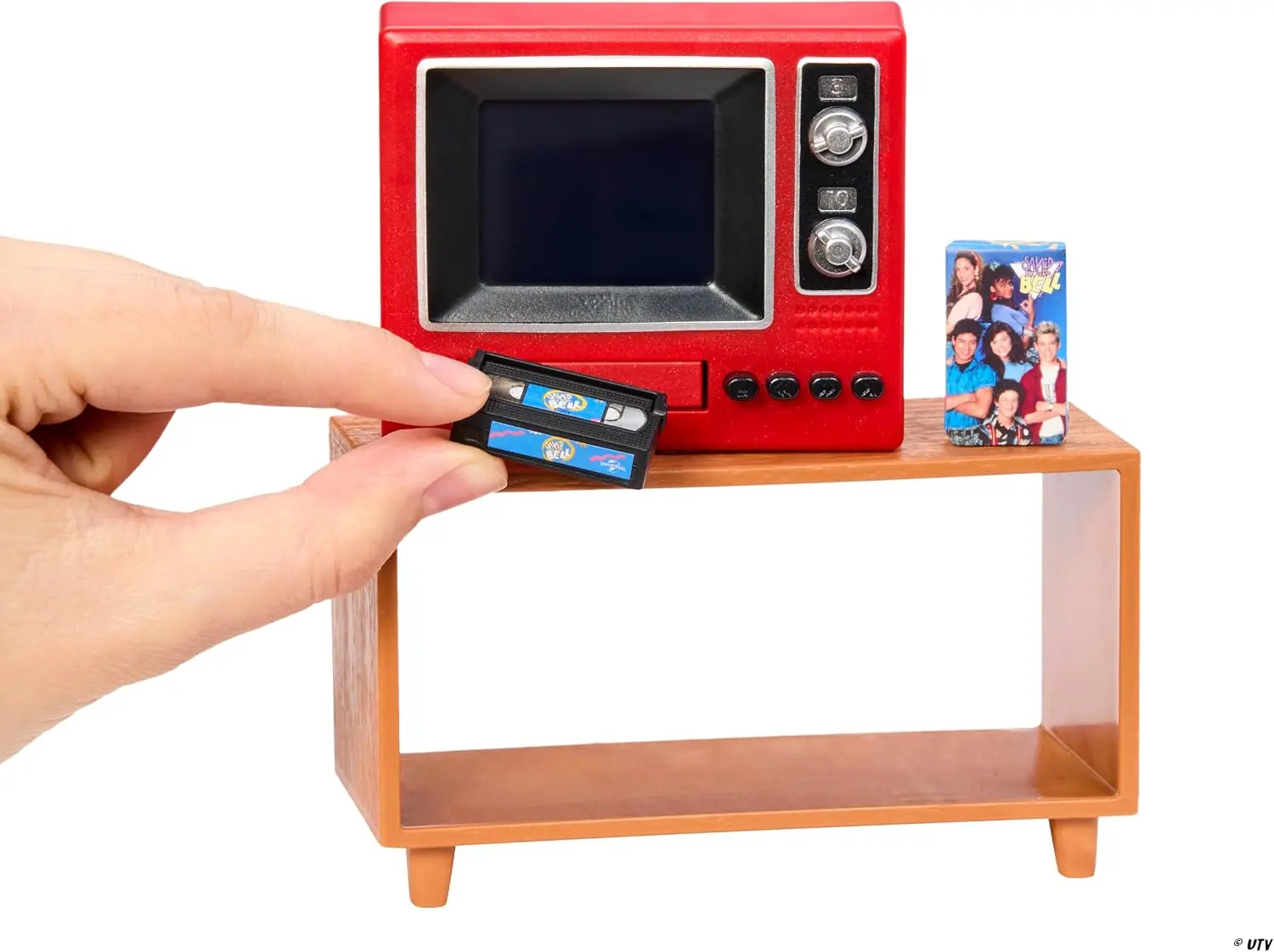 A hand pushes a mini tape into the front slot of the Miniverse Real TV Player, showing the real scale of the set