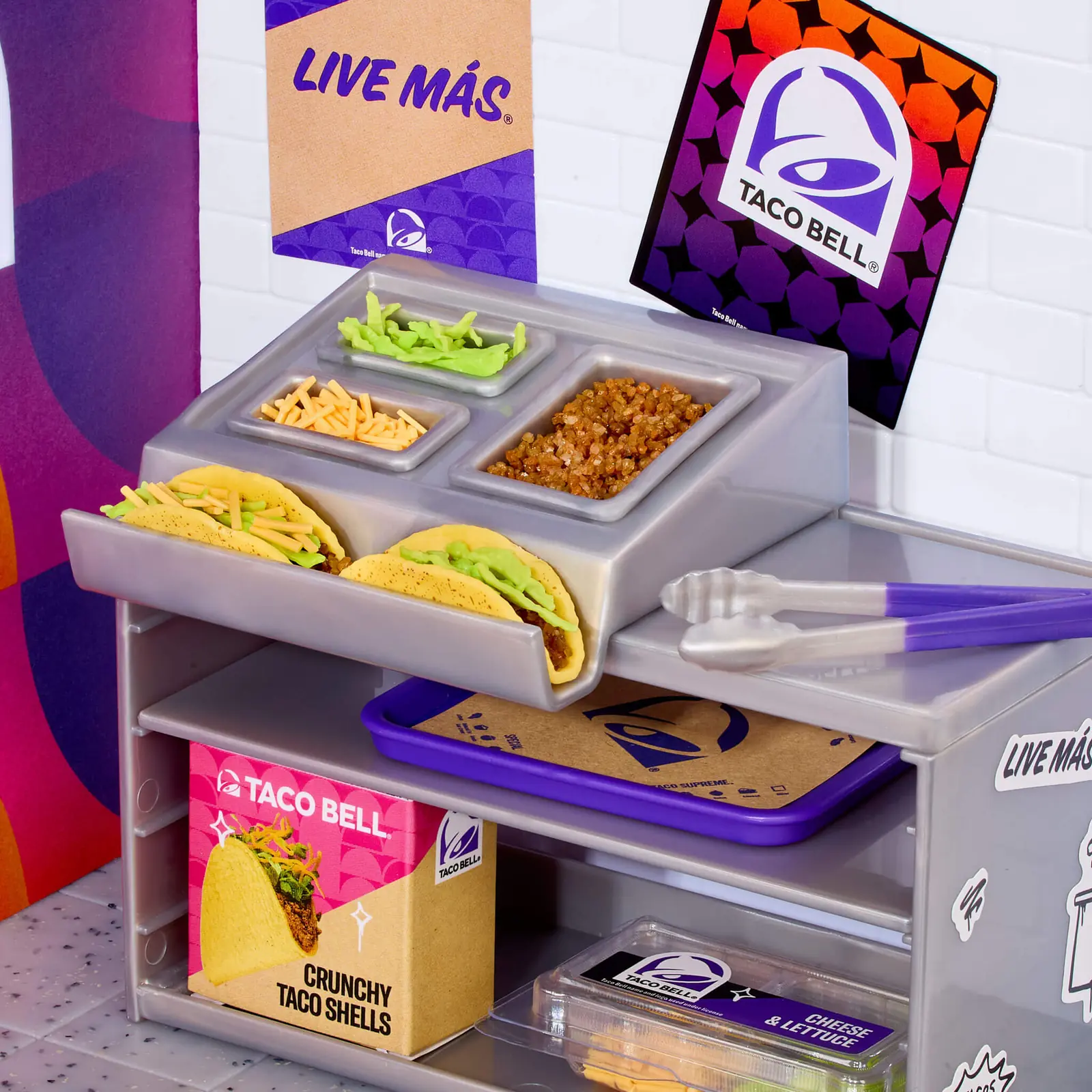 Estación de tacos del Miniverse Taco Bell Restaurant con cubetas de relleno, pinzas, bandeja y caja de Crunchy Taco Shells
