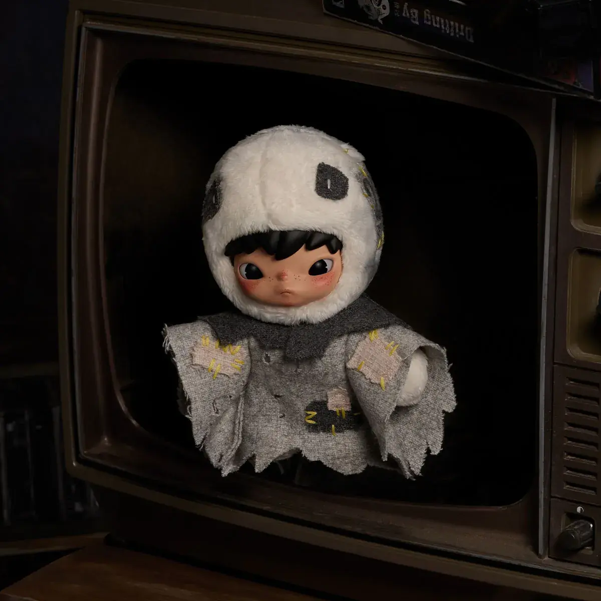 Peluche colgante de HIRONO After Dark dentro de un televisor antiguo
