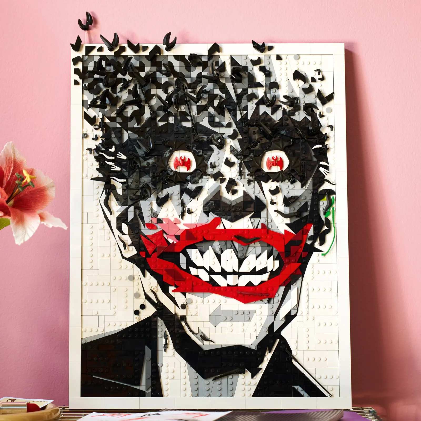 Arte mural LEGO 67012 del Joker apoyado en una pared rosa