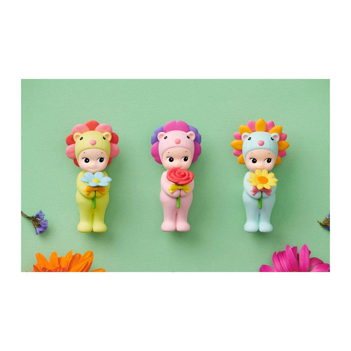 Sonny Angel Flower Gift: tres figuras león con melena de flor sosteniendo margarita, rosa y girasol sobre fondo verde